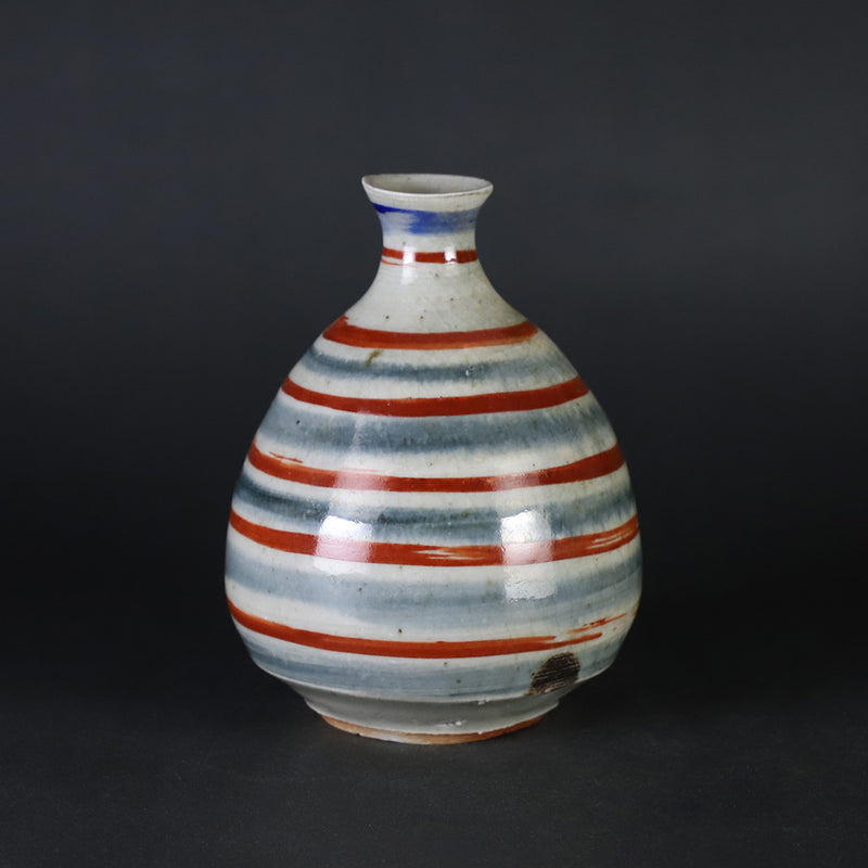 Red-painted spinning top design bottle by Shingo Oka