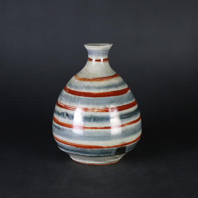 Red-painted spinning top design bottle by Shingo Oka