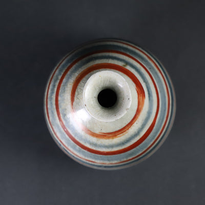 Red-painted spinning top design bottle by Shingo Oka