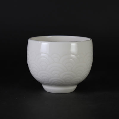 White porcelain sake cup with blue sea wave pattern by Manji Inoue