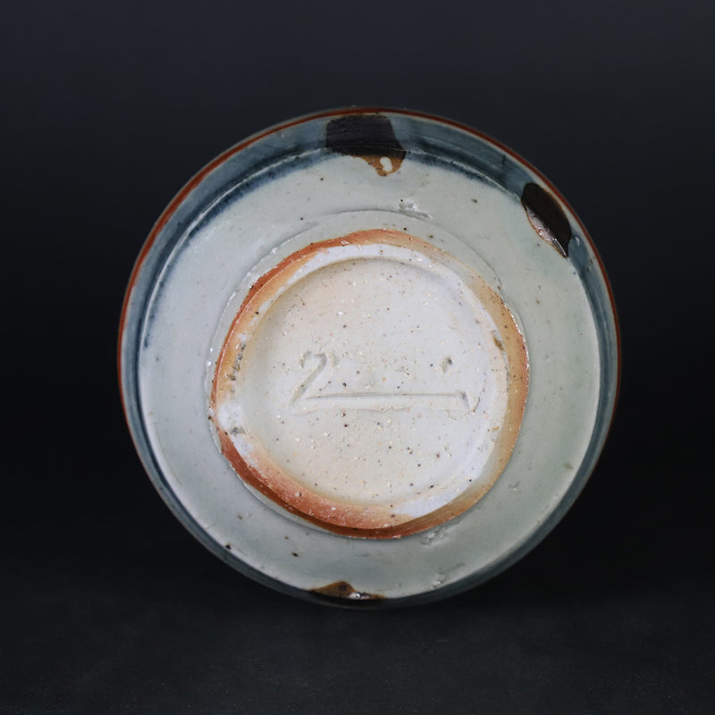 Red-painted spinning top design bottle by Shingo Oka