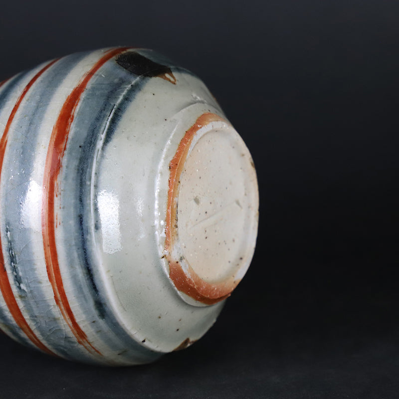 Red-painted spinning top design bottle by Shingo Oka