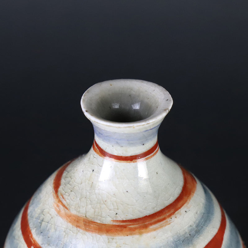 Red-painted spinning top design bottle by Shingo Oka