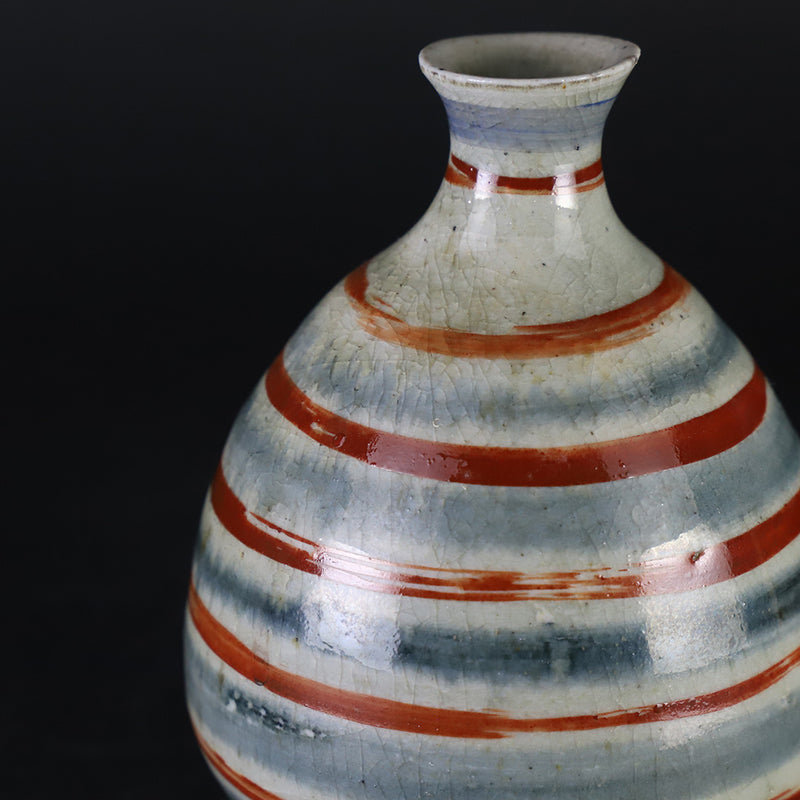 Red-painted spinning top design bottle by Shingo Oka