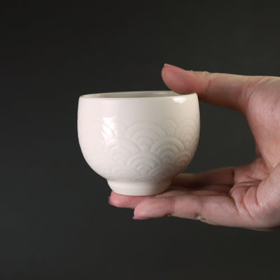 White porcelain sake cup with blue sea wave pattern by Manji Inoue