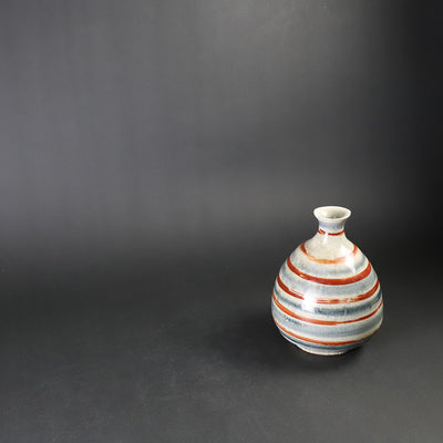 Red-painted spinning top design bottle by Shingo Oka