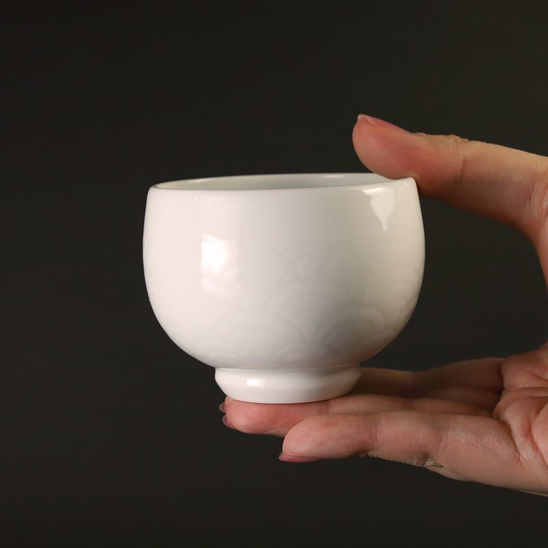 White porcelain sake cup with blue ocean wave pattern by Manji Inoue